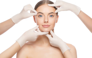Woman's face surrounded by gloved hands for aesthetic consultation
