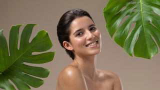 Smiling woman, radiant skin, surrounded by leaves