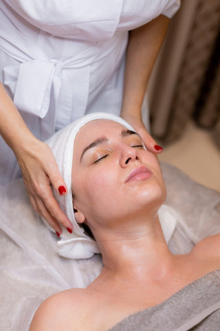 Woman receiving facial massage treatment at Leor Clinic